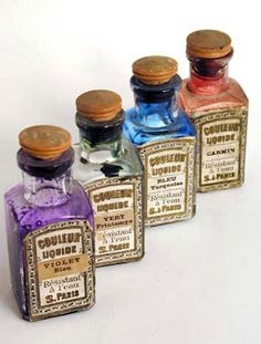 four bottles with different colored liquids in them