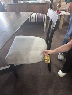 a person sitting at a table with a piece of furniture in front of them on the floor