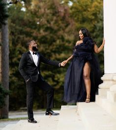 a man in a tuxedo and a woman in a black dress holding hands