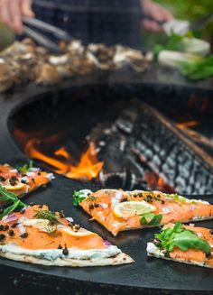 several pieces of salmon are cooking on an outdoor grill