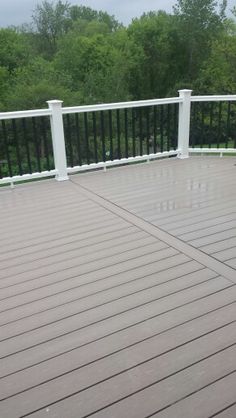 a deck with white railings and black rails