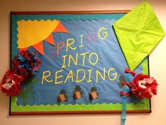 a bulletin board that says spring into reading with paper flowers and kites on it