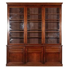 an old wooden bookcase with glass doors on the top and bottom shelves, all in dark wood