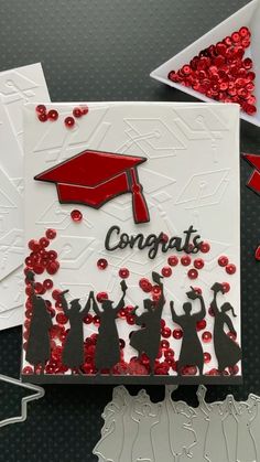 congratulations card with red confetti and graduation cap on it, surrounded by other greeting cards