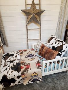 a bed with pillows, blankets and a star on the wall above it in a bedroom