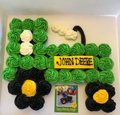 a cake made to look like a tractor with green icing and flowers on it