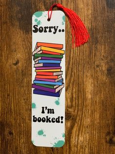 a bookmark with the words sorry i'm bookseed on it and a red tassel