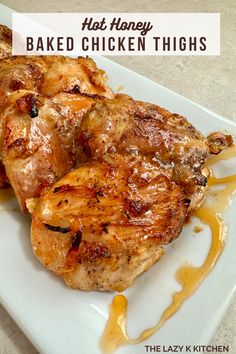 grilled chicken thighs on a white plate with honey drizzle