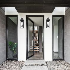 an entrance to a modern home with stone steps