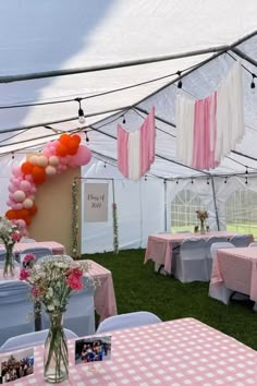 tables and chairs are set up in a tent for an event with pink and white checkered tablecloths