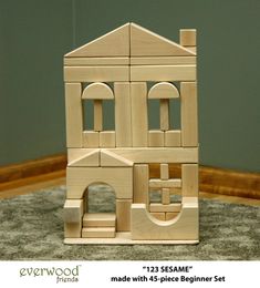 a wooden toy house sitting on top of a rug