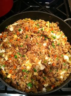 a pan filled with rice and vegetables on top of a stove