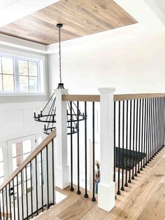 an empty room with stairs and railings in the center, next to a window