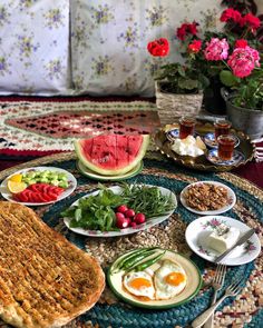 an assortment of food is displayed on a table with flowers in the backgroud