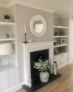 a living room filled with furniture and a fire place in front of a white fireplace