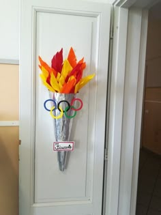 a door decorated with paper flowers and the olympic rings hanging on it's side