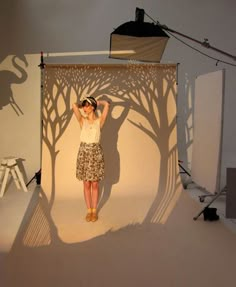 a woman is standing in front of a photo studio with her hands behind her head