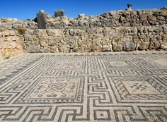 an ancient mosaic in the middle of a stone wall