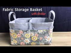 fabric storage basket with divider on wooden table next to black wall and blue background