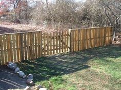 a wooden fence in the middle of a yard