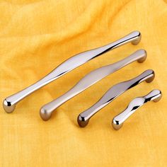 three shiny metal handles on a yellow cloth