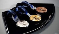 four medals are placed on a black tray