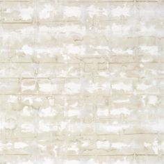 a white brick wall that has been painted in shades of gray and beige with some light brown highlights