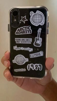 someone holding up their phone case with stickers on it