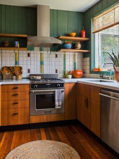 a kitchen with wooden floors and green walls