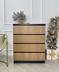 a wooden dresser sitting next to a christmas tree