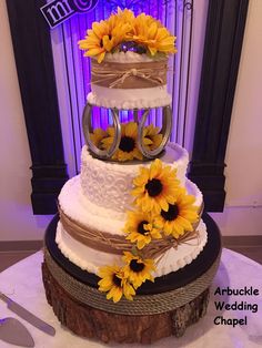 a wedding cake with sunflowers on top