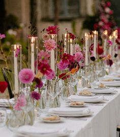 a long table is set with flowers and candles