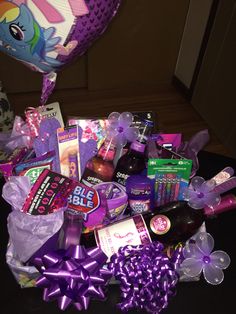 a purple basket filled with lots of candy and other items on top of a table