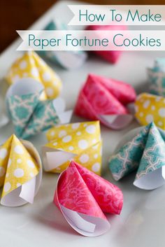 several origami paper flowers on a white table with yellow and blue dots in the background