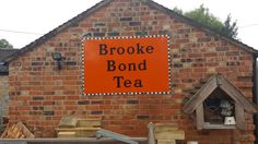 a brick building with a sign that says brooke bond tea hanging on the side of it