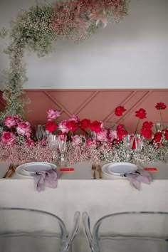 the table is set with place settings and flowers