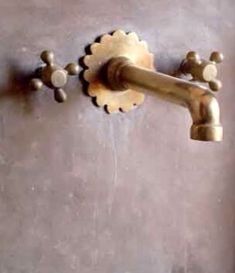 an old fashioned faucet is attached to the wall with two handles and knobs