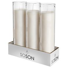 three candles are sitting in a box with the label soson on it's side