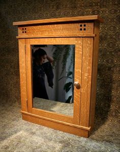 the reflection of a woman in a mirror is seen through a wooden frame on the wall