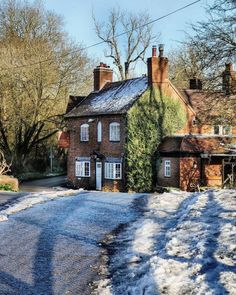 an old brick house with snow on the ground and trees in the backgroud