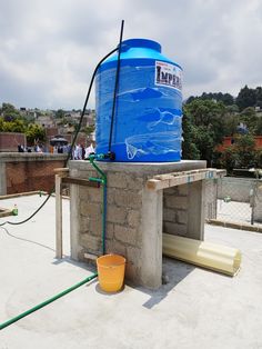 a large blue water tank sitting on top of a cement structure