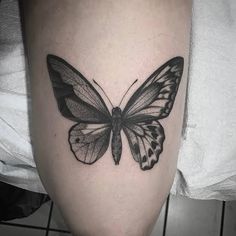 a black and white butterfly tattoo on the leg