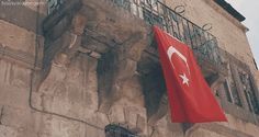 a red flag hanging from the side of a building