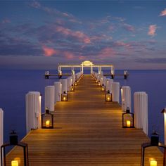 a pier with lanterns lit up at night