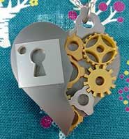 a heart shaped key with two gears attached to it on a blue tablecloth background