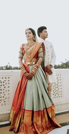 a man and woman standing next to each other on top of a white fenced in area