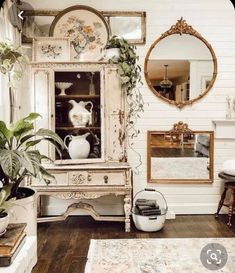 a living room filled with lots of furniture and plants on top of wooden flooring