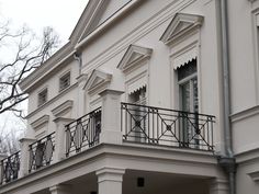 a white building with black balconies and wrought iron railings on the balcony