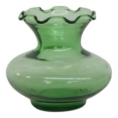 a green glass vase sitting on top of a table