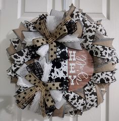 a black and white wreath that says happy new year on the front door with cow print